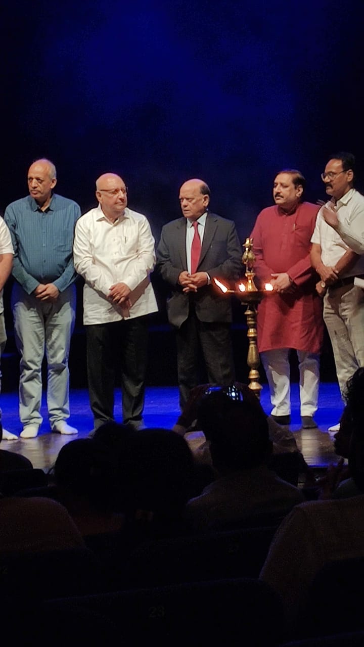 Guests gathered beside a ceremonial lamp on stage